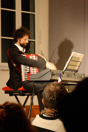 Kitschen spielt Klavier und Akkordeon gleichzeitig